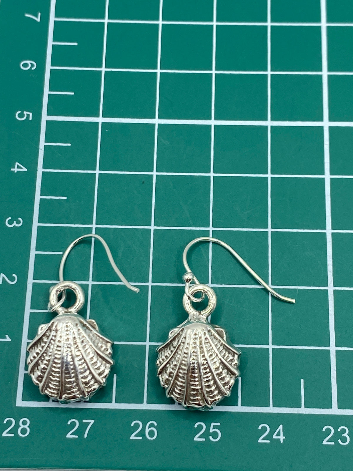Reverso de los aretes mostrando el trabajo de repujado desde atrás