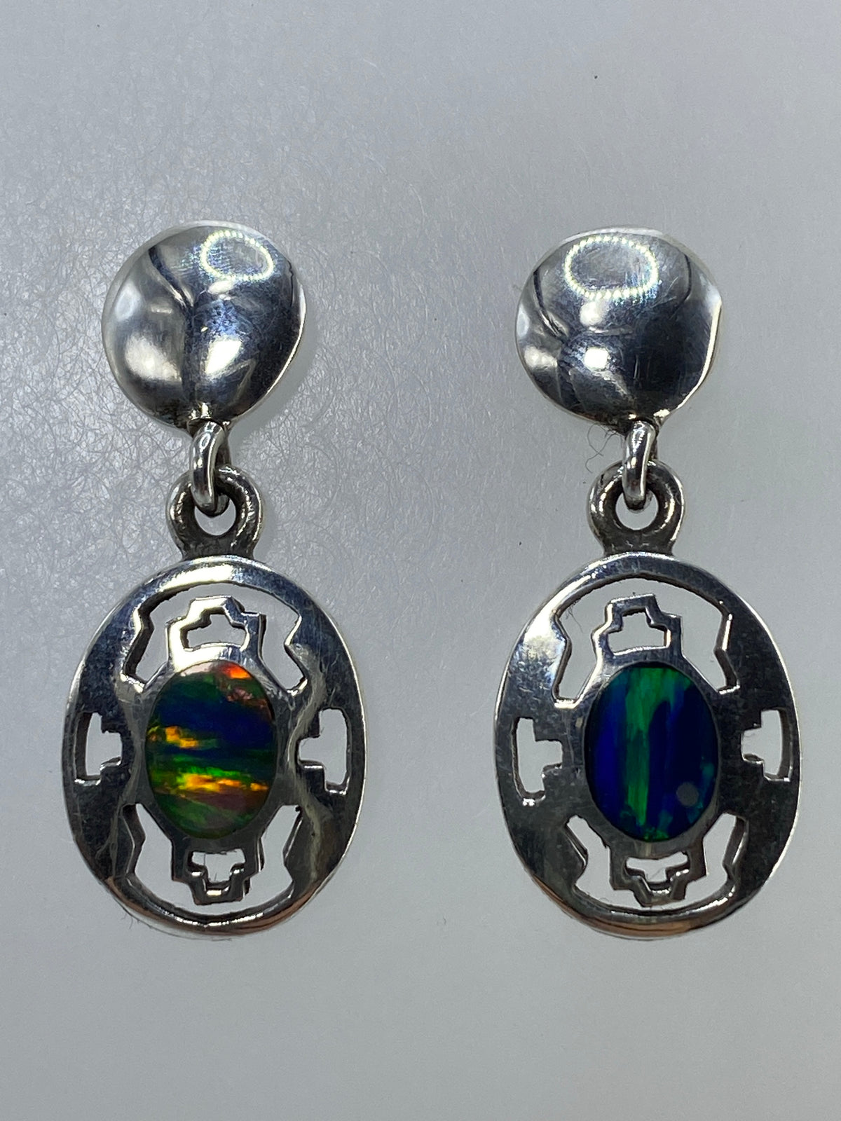 Detalle del engaste a mano del ópalo de fuego en aretes de plata Taxco