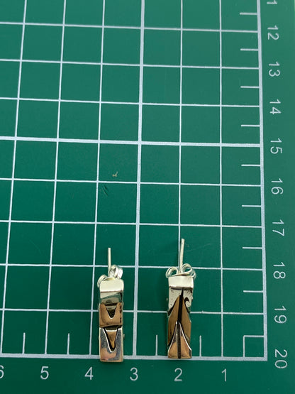 Aretes en balanza mostrando peso de 5.99 gramos