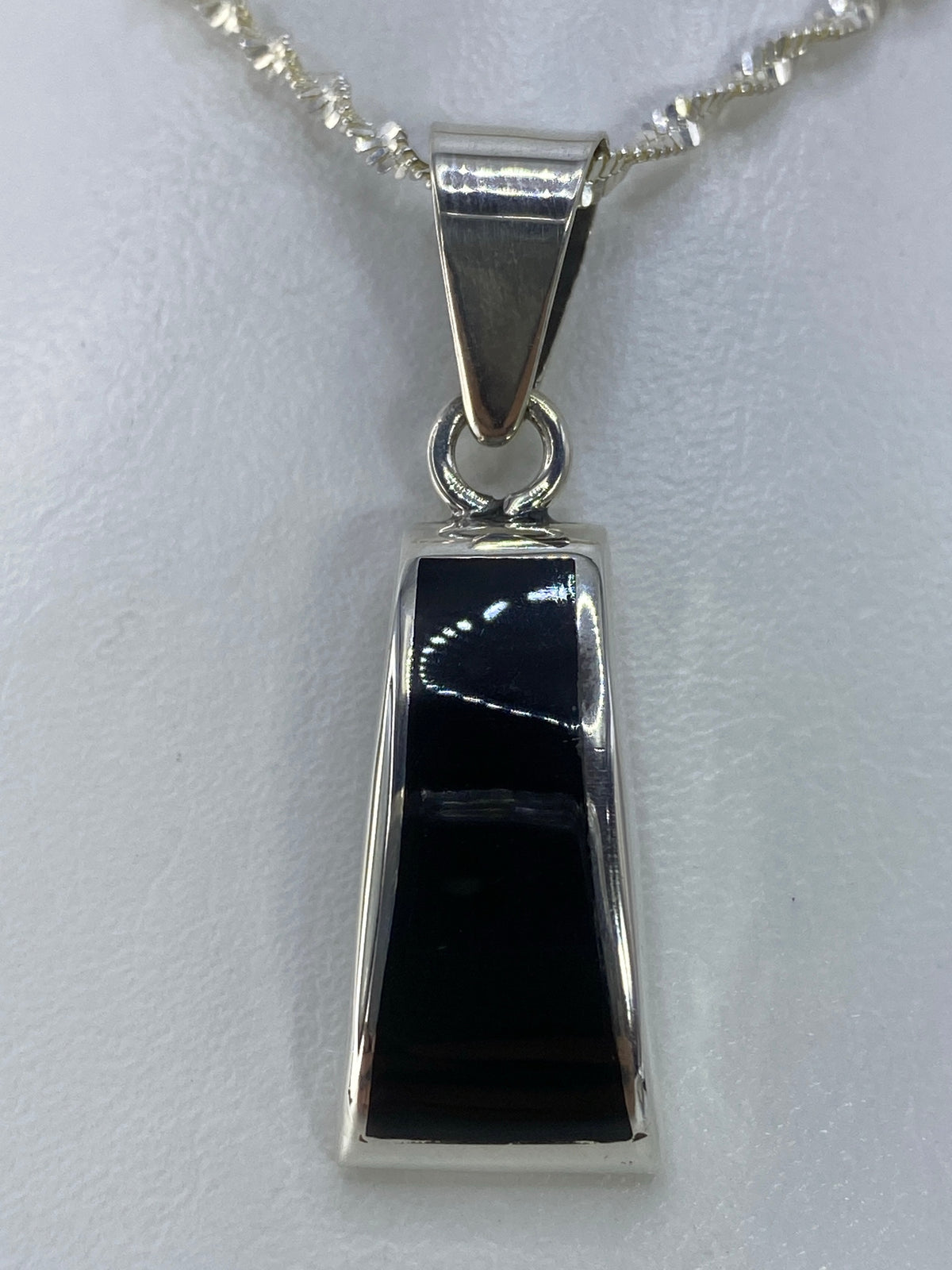 Vista frontal del dije de ónix negro en plata, detalle del engaste