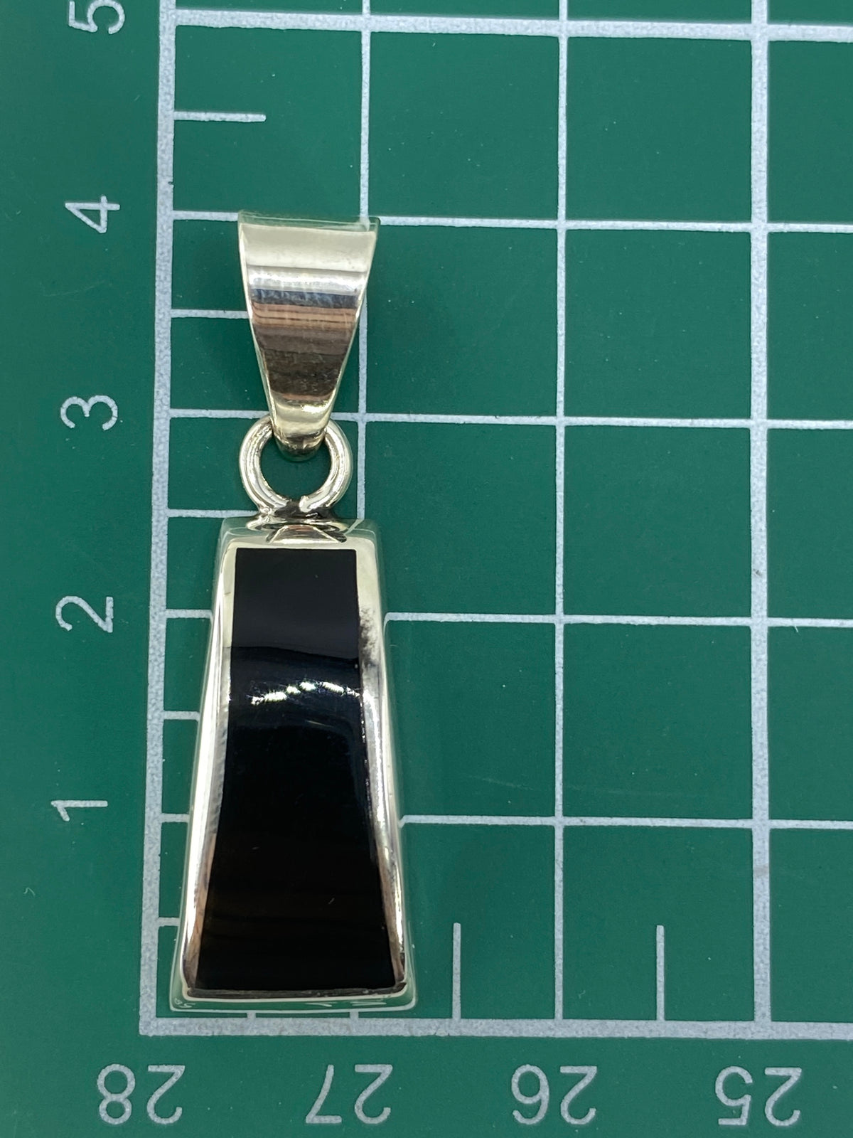 Reverso del dije de plata con Quinto de autenticidad visible