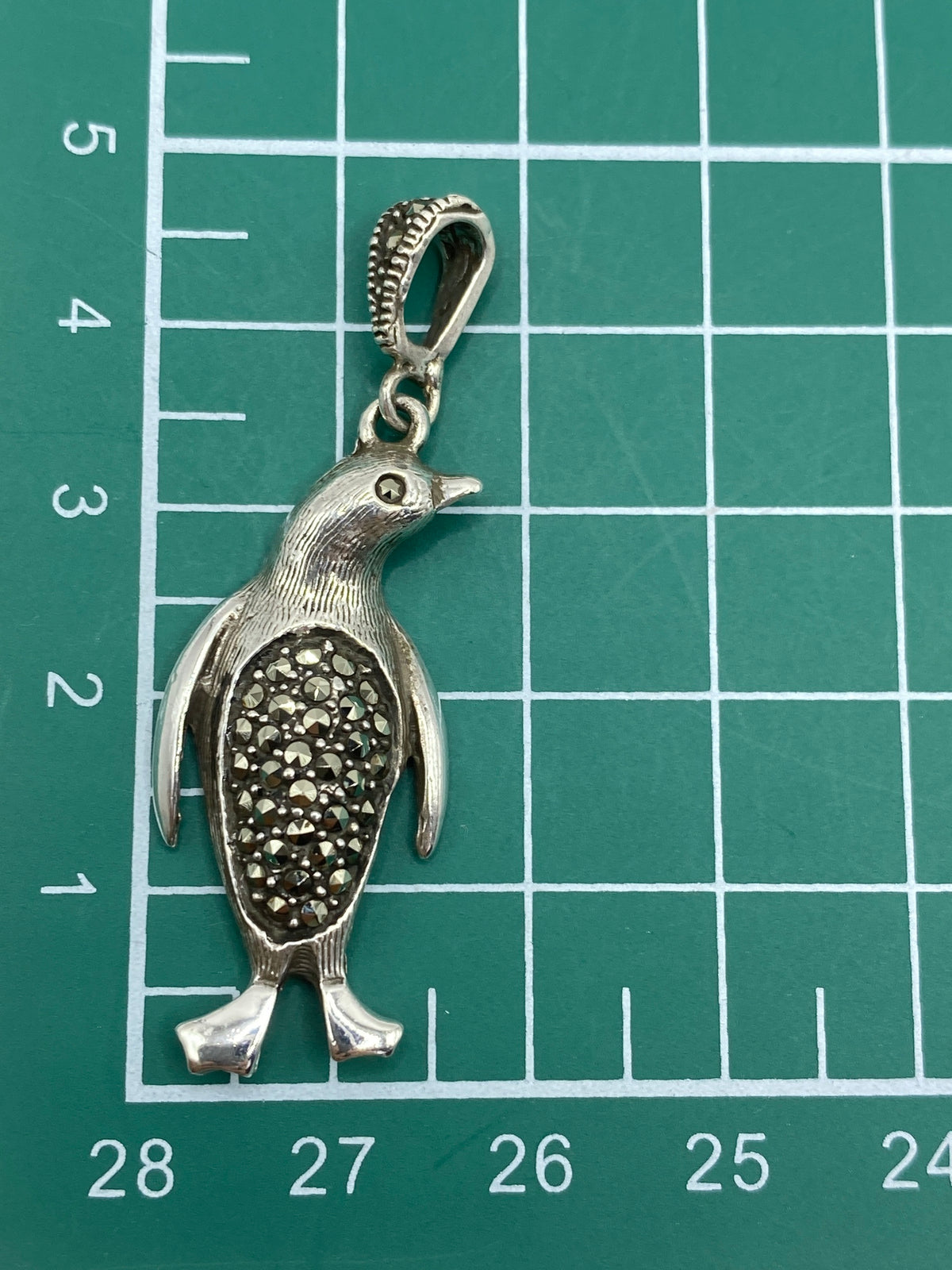 Dije de pingüino de Taxco sobre papel blanco, mostrando el tamaño de 4.7 cm y el Quinto 925