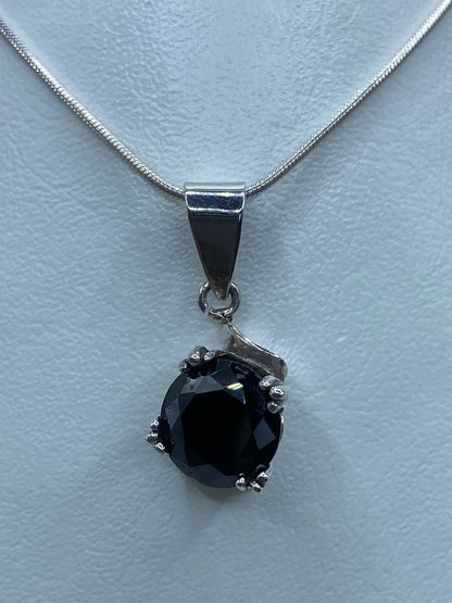 Detalle del engaste de circonia negra con garras de plata en el dije