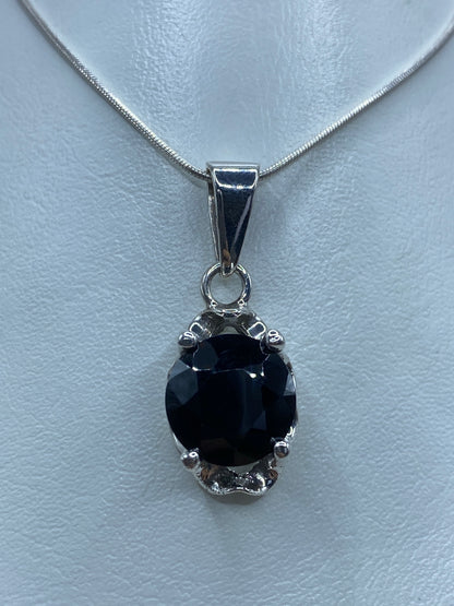 Dije de plata 925 con circonia negra engastada, colgando de una cadena de serpentina fina