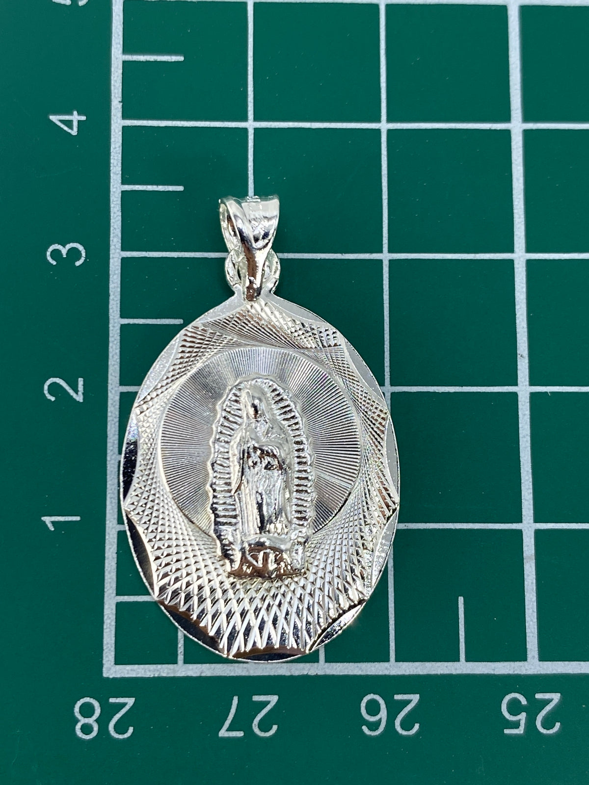Dije de Guadalupe en la mano, tamaño 3.4 cm, con Quinto 925 visible