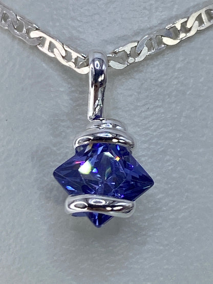 Detalle del dije mostrando el engaste de circonia azul y el pulido de plata 925