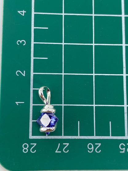 Dije de plata con circonia azul desde ángulo lateral en fondo blanco