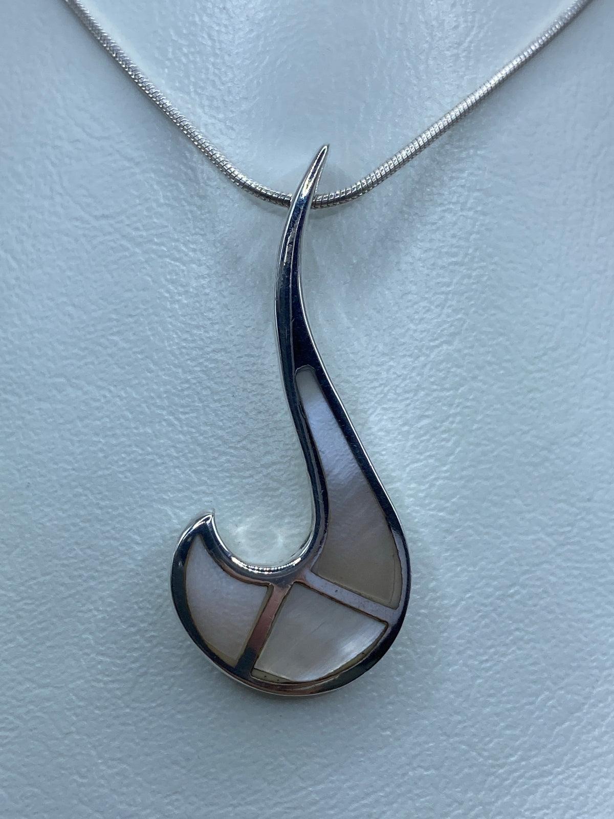 Dije de plata en forma de gota con madre perla blanca engastada, colgando de cadena de plata