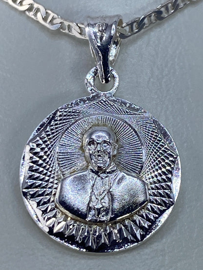 Detalle del repujado de Taxco en el dije religioso de plata 925