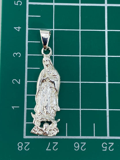 Dije de Virgen María en plata sobre fondo blanco para escala de tamaño