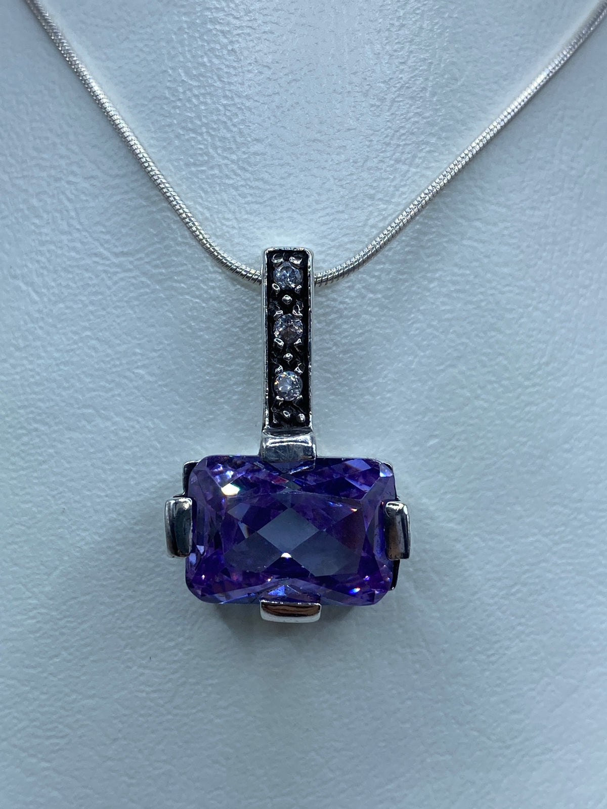 Dije de plata 925 con micro-circonia blanca y circonia morada en cadena delgada de plata