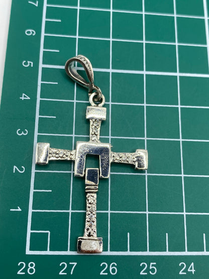 Cruz sobre regla mostrando medidas de 5.5 cm de largo × 3 cm de ancho