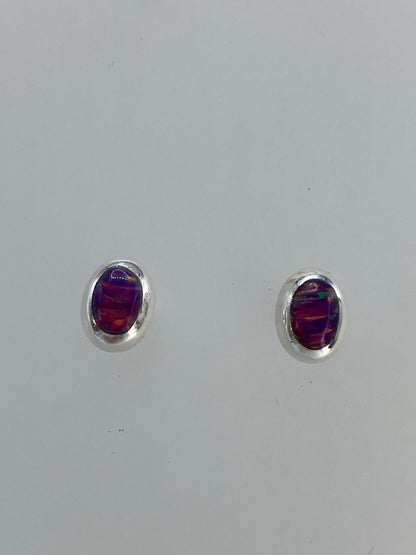 Aretes de ópalo de fuego rosa en plata, mostrando el brillo multicolor de la piedra