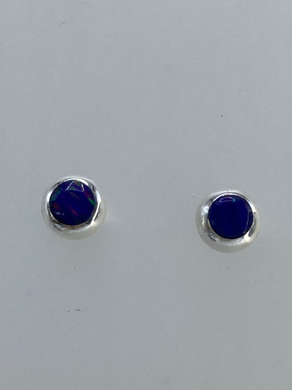 Aretes de plata con ópalo de fuego azul, mostrando el color intenso y los destellos de luz en el par