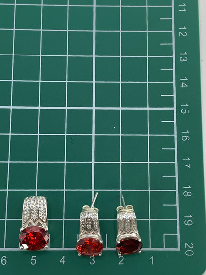 Los tres aretes del set con la escala de medida en centímetros
