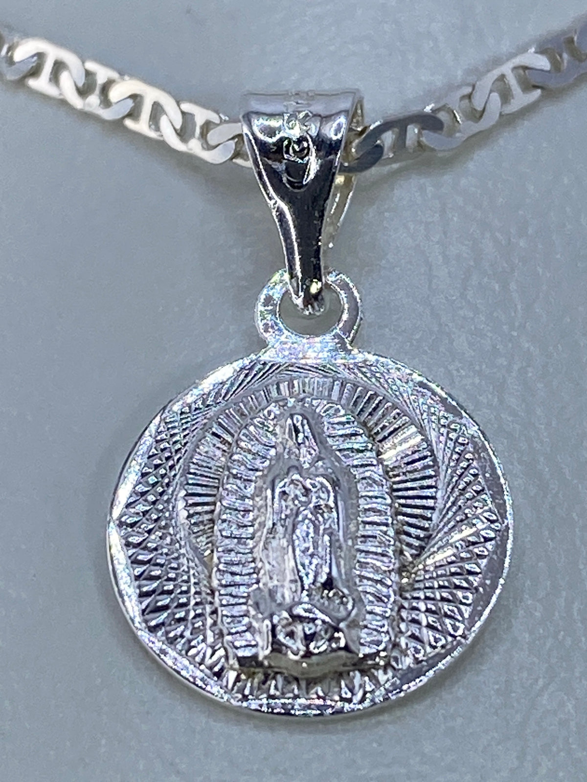 Detalle del repujado de la Virgen de Guadalupe con mandorla radiante en plata