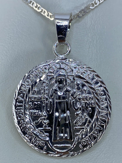 Dije San Benito repujado en plata 925 de Taxco, frente con figura de santo y cruz central