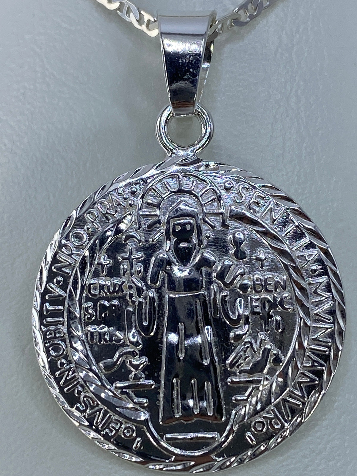 Detalle del repujado a mano y relieve de San Benito con sus atributos