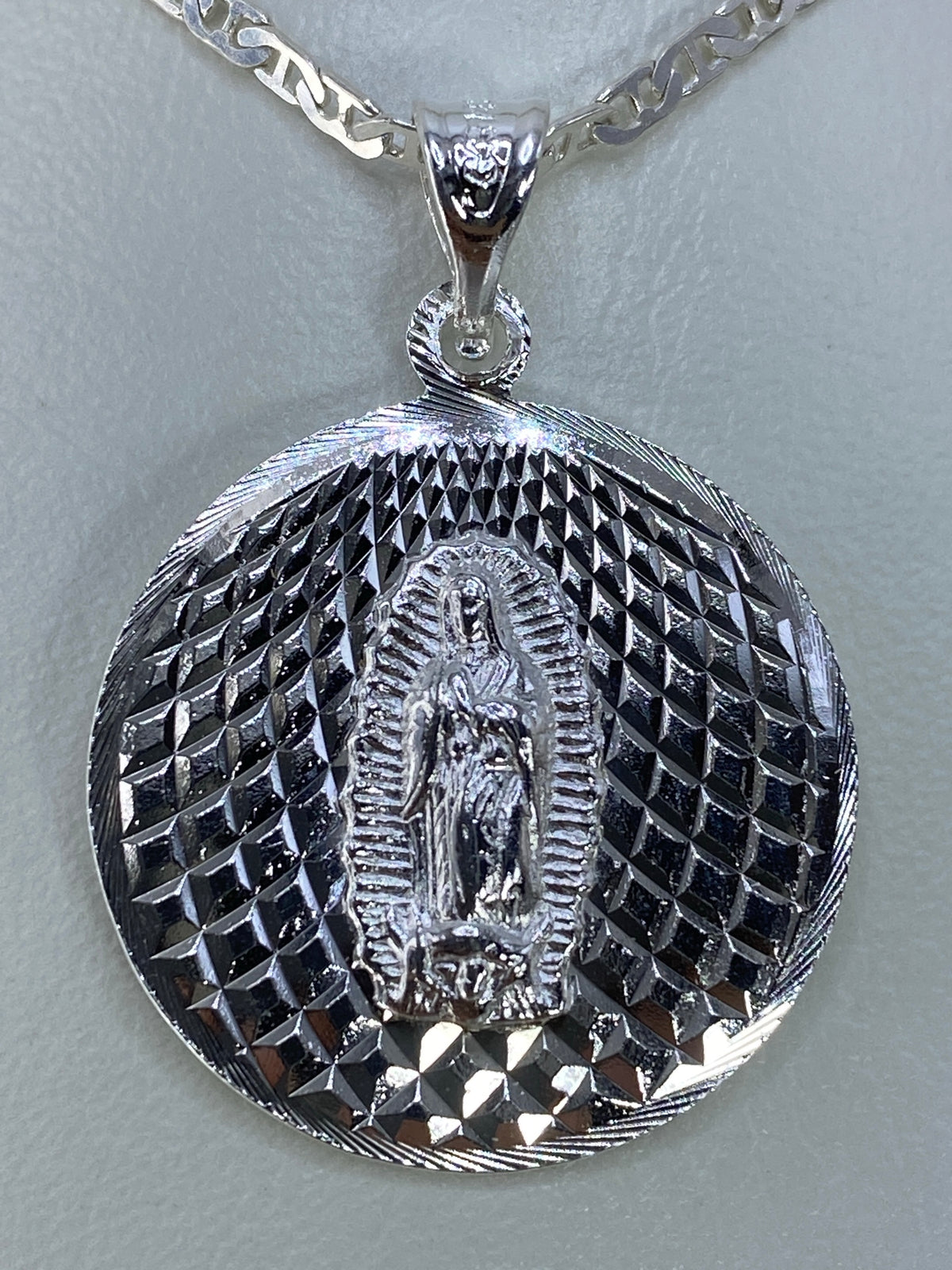 Dije de plata repujado con la Virgen de Guadalupe y aureola radiante
