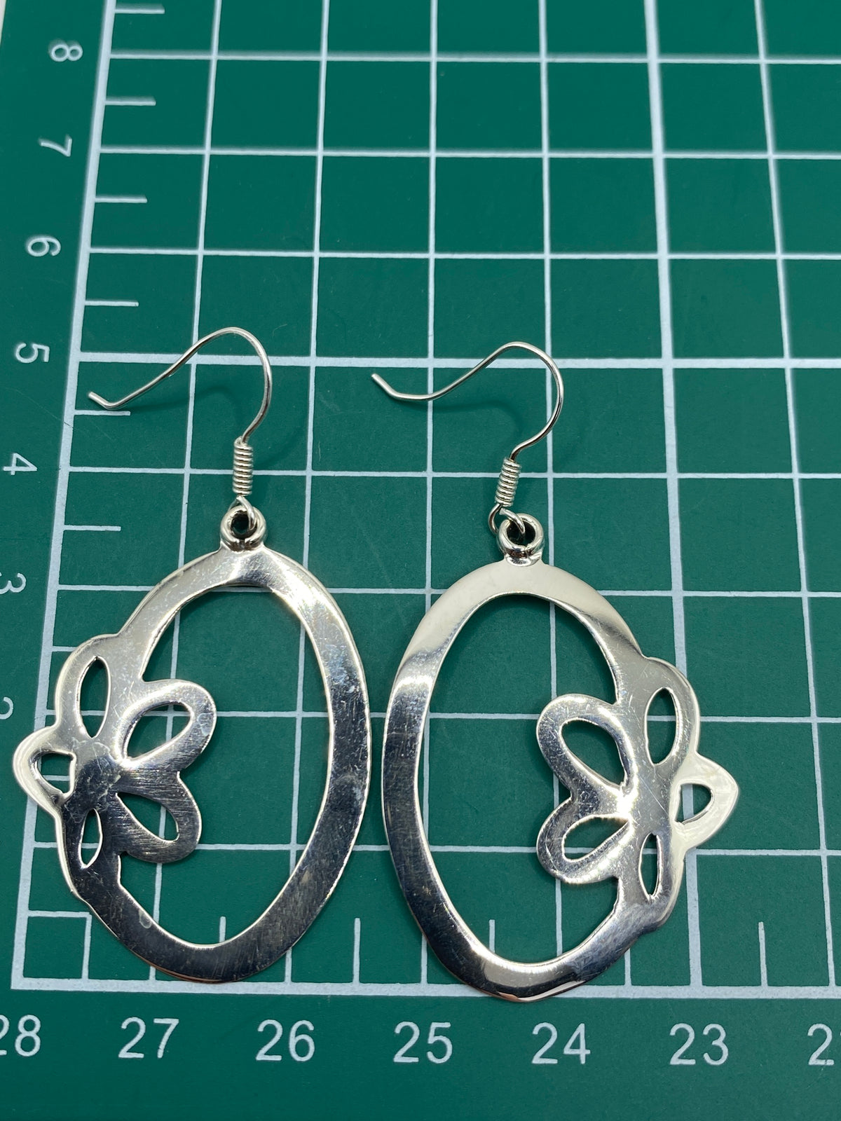 Los aretes en la muñeca mostrando el tamaño real de 4.9 cm