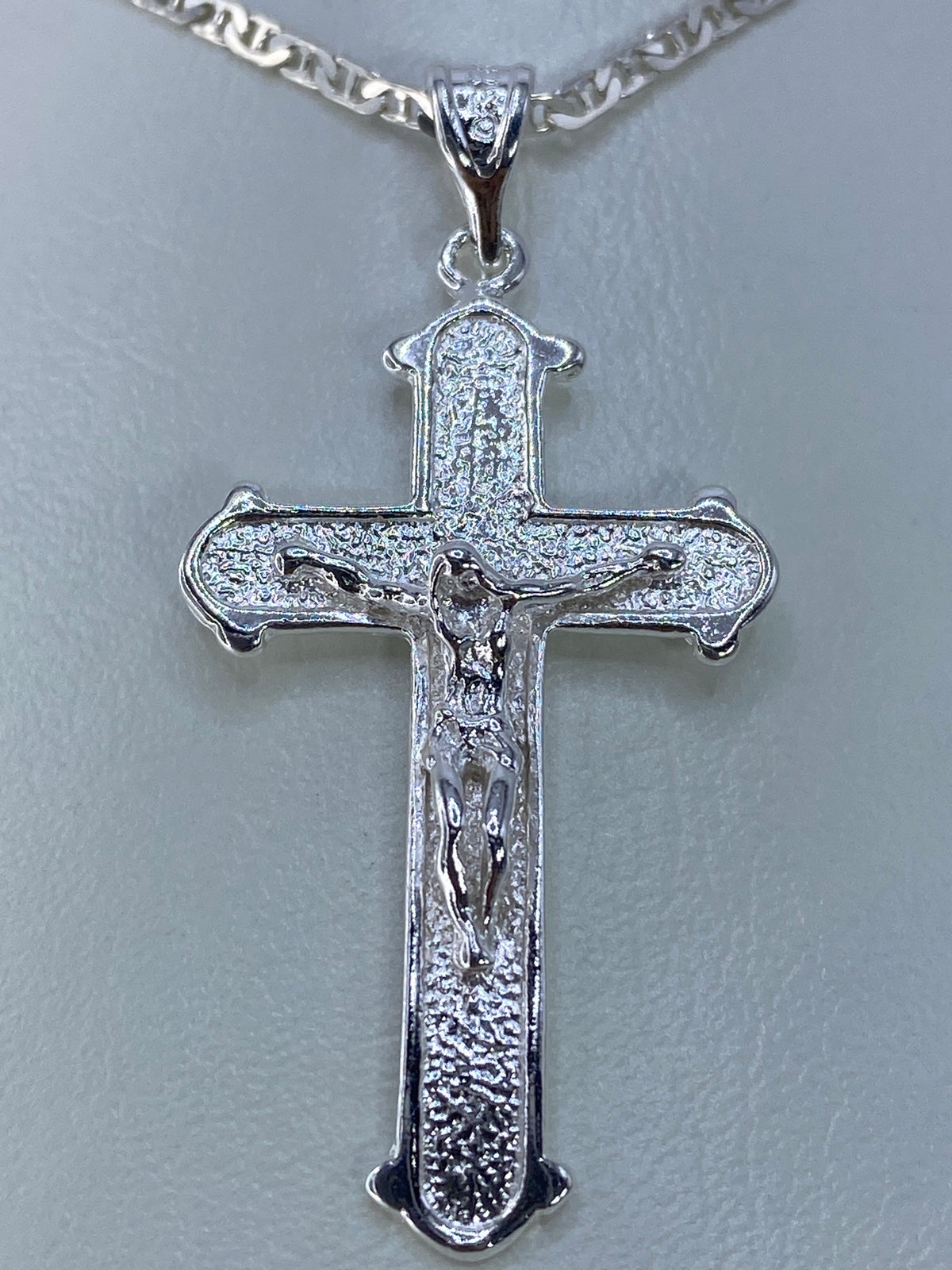 Detalle del repujado: relieve de Cristo en la cruz, técnica de martillo y punzón de Taxco