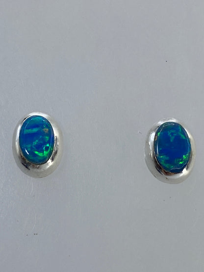 Par de aretes de plata con ópalo de fuego multicolor, vista frontal sobre fondo blanco