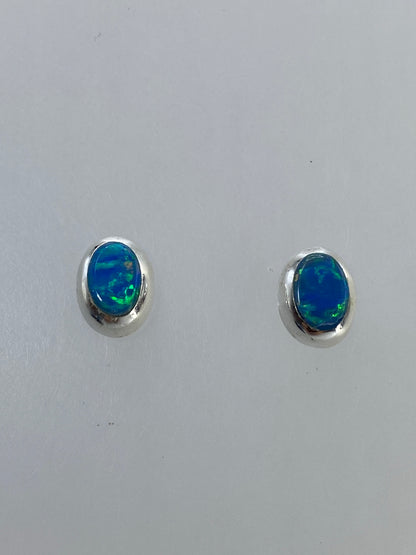 Detalle del engaste a mano del ópalo en plata 925, mostrando los colores verdes y azules
