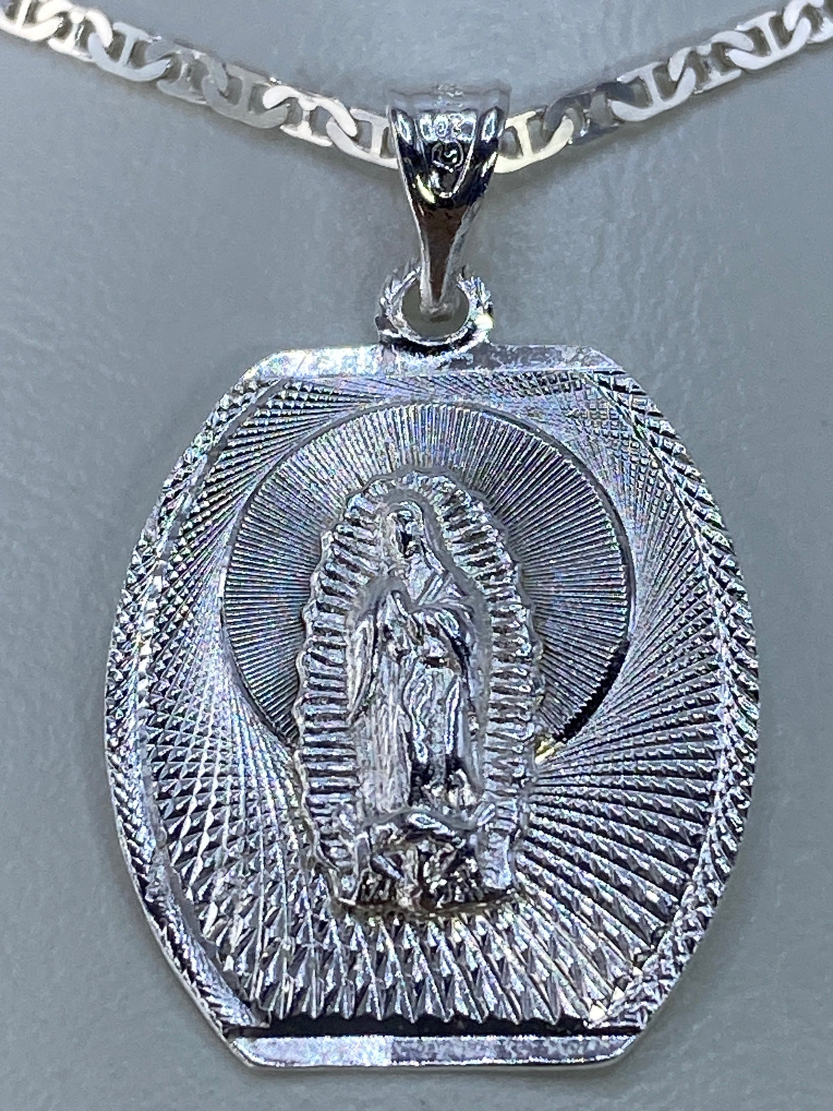 Vista detallada del relieve repujado de la Virgen de Guadalupe en plata 925