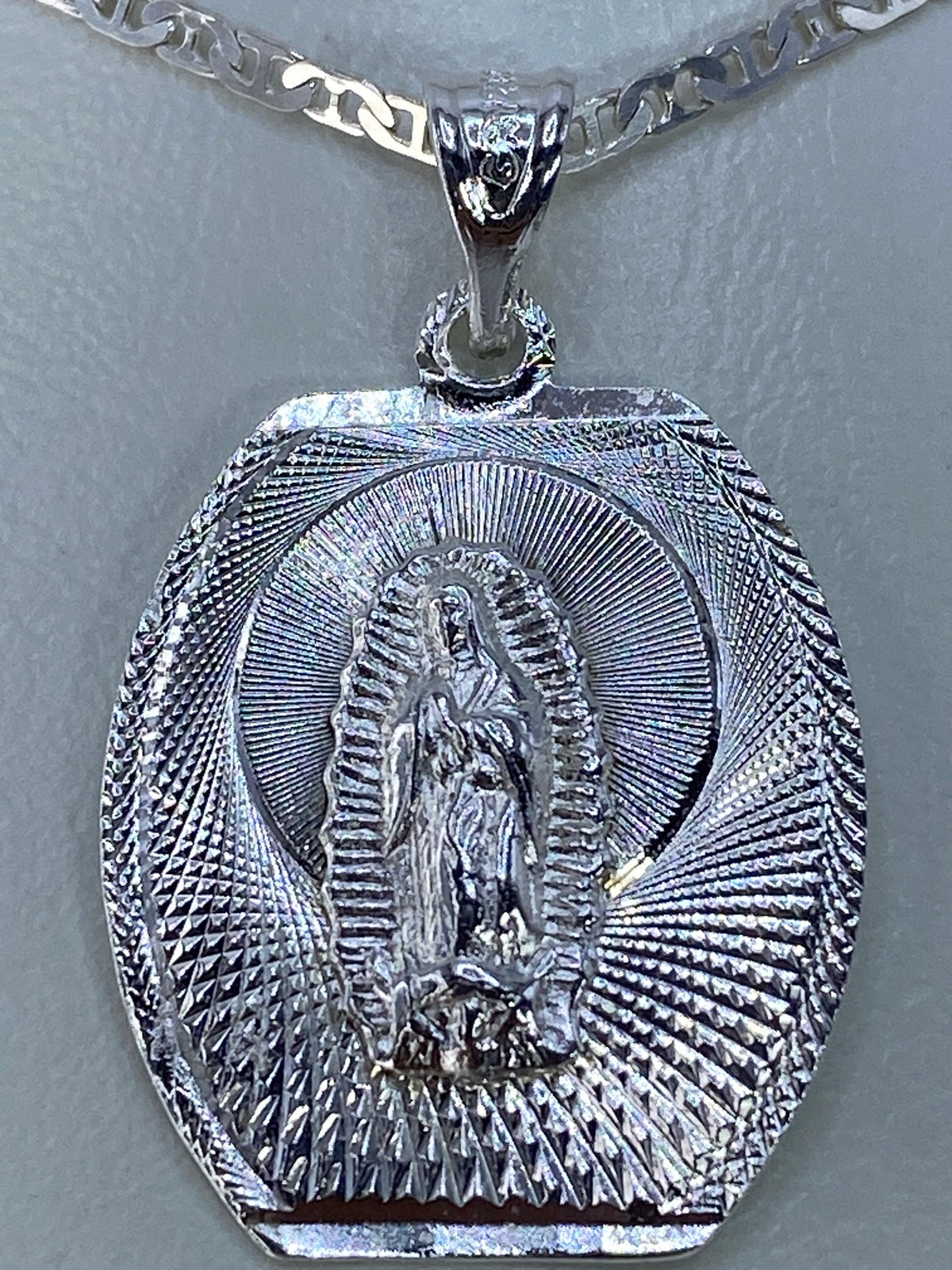 Dije de 3.3 cm mostrando el acabado pulido y los detalles en alto relieve