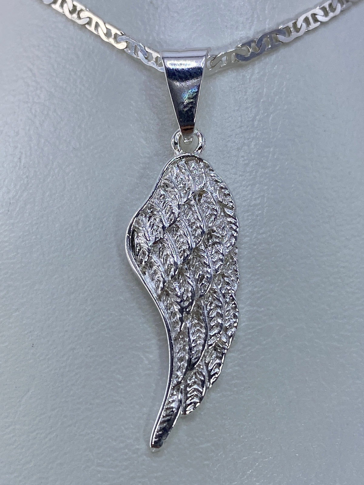 Ala de plata repujada de 3.8 cm colgada en cadena, luz frontal