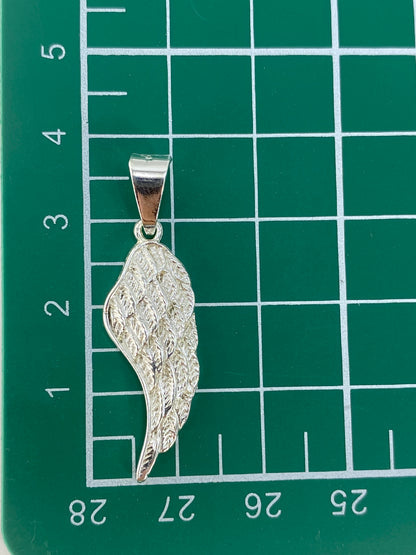 Ala de plata sobre escala de medición, confirmando 3.8 cm de largo