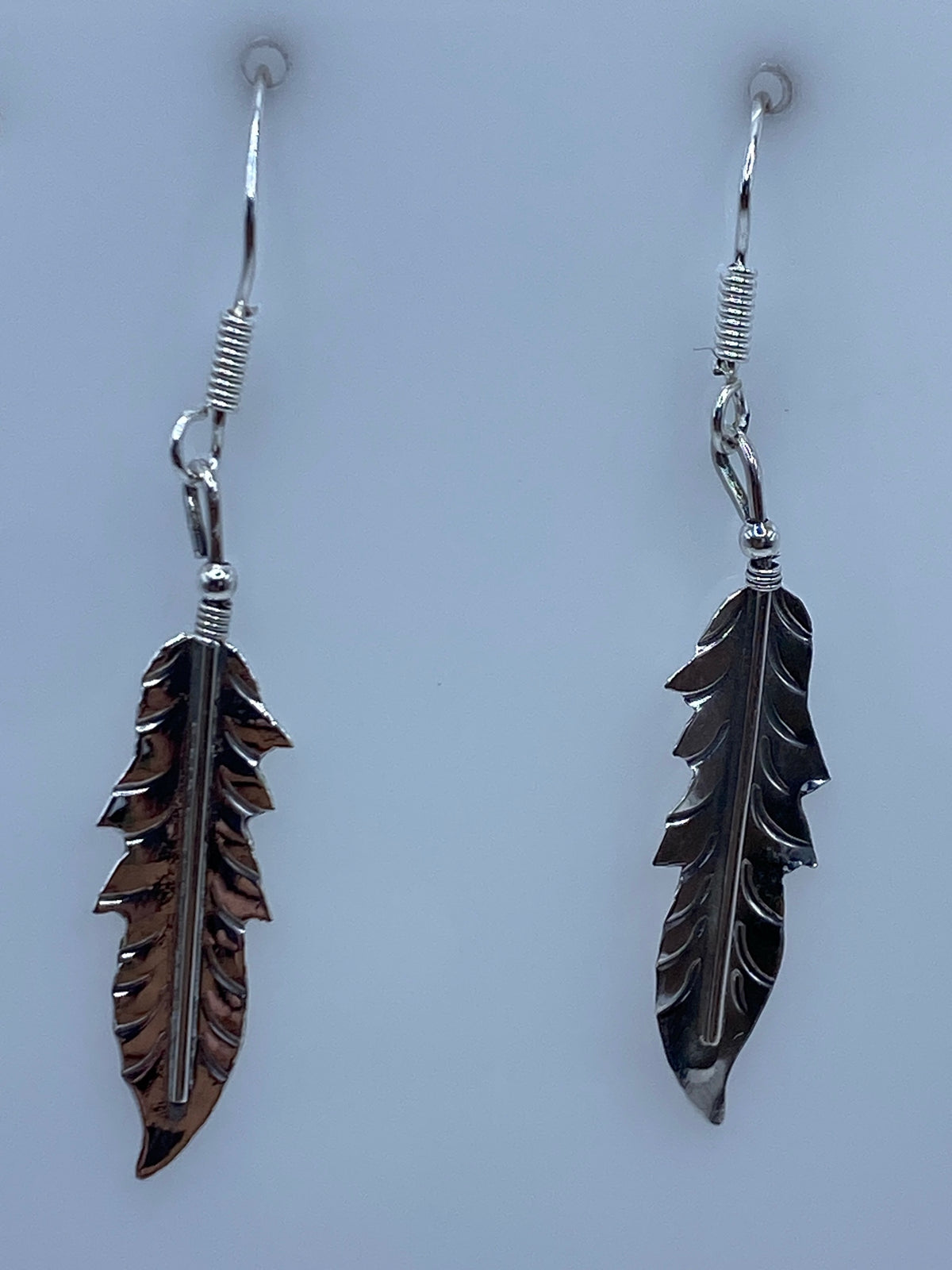 Par de aretes de plata con hojas repujadas en relieve, colgando de ganchos de plata 925