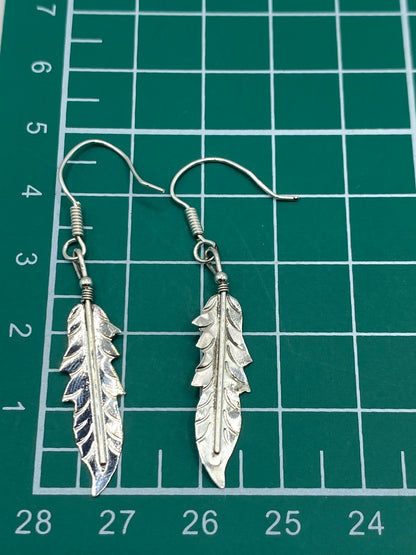 Aretes de plata 925 repujados sobre fondo blanco mostrando el acabado mate y brillo del relieve