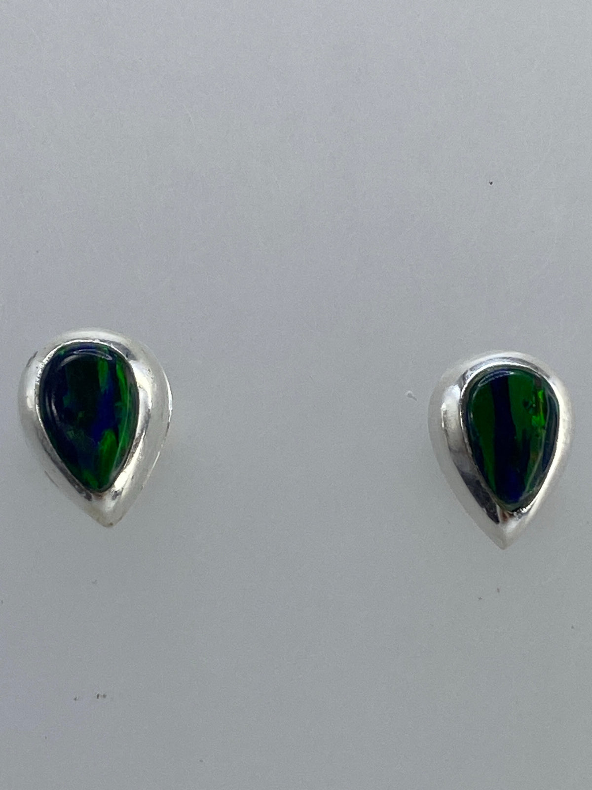 Aretes de frente mostrando la forma de lágrima y el brillo del ópalo