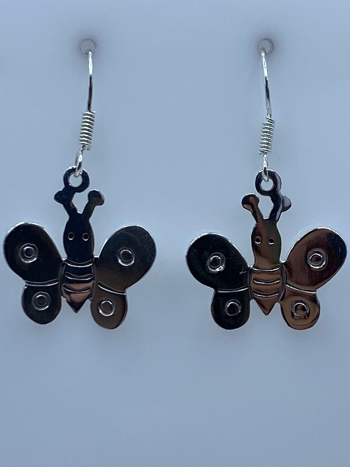 Par de aretes de plata con diseño de mariposa, alas redondeadas y cuerpo detallado