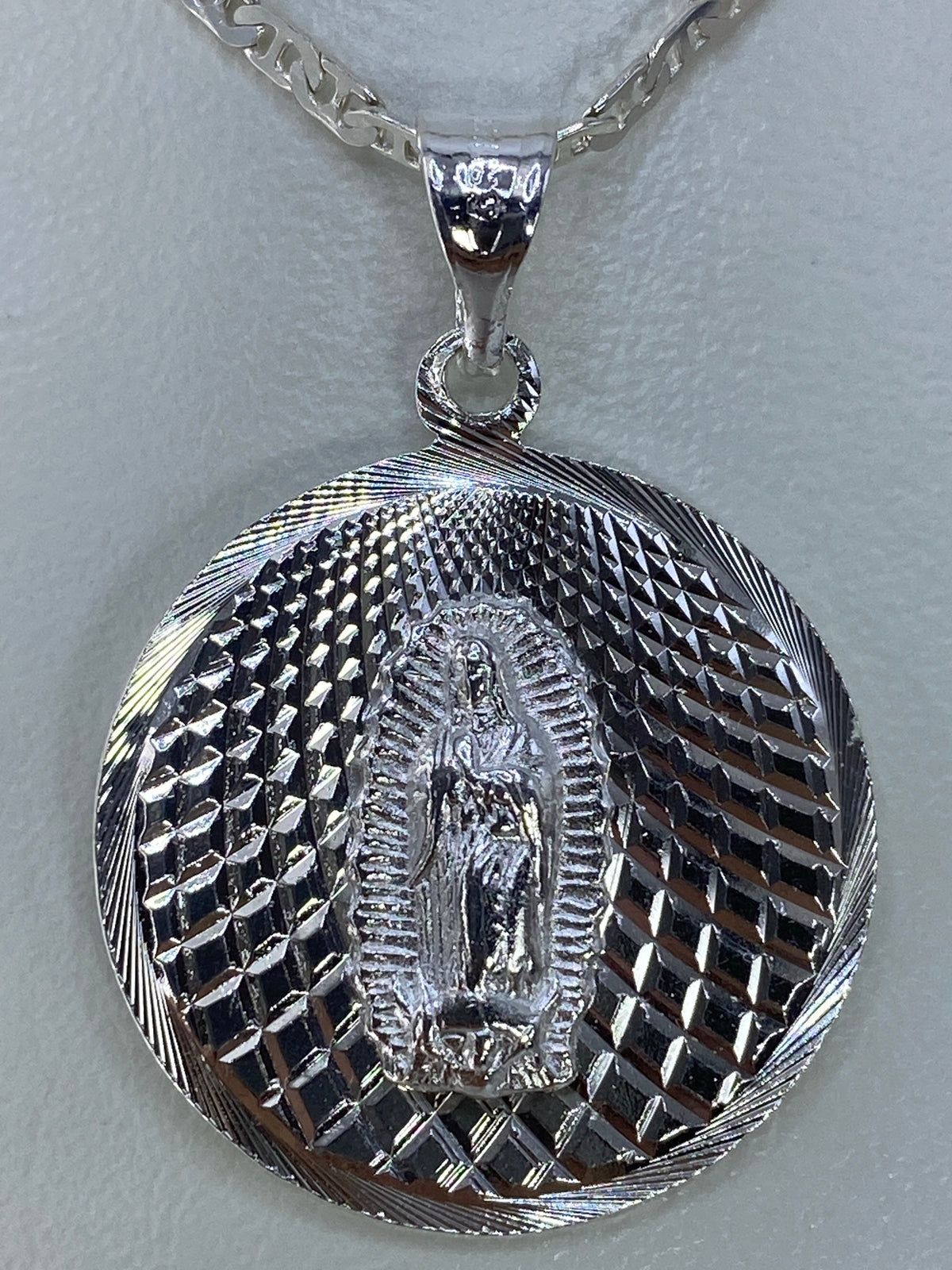 Dije de plata 925 con la Virgen de Guadalupe en relieve repujado, colgando de cadena plateada