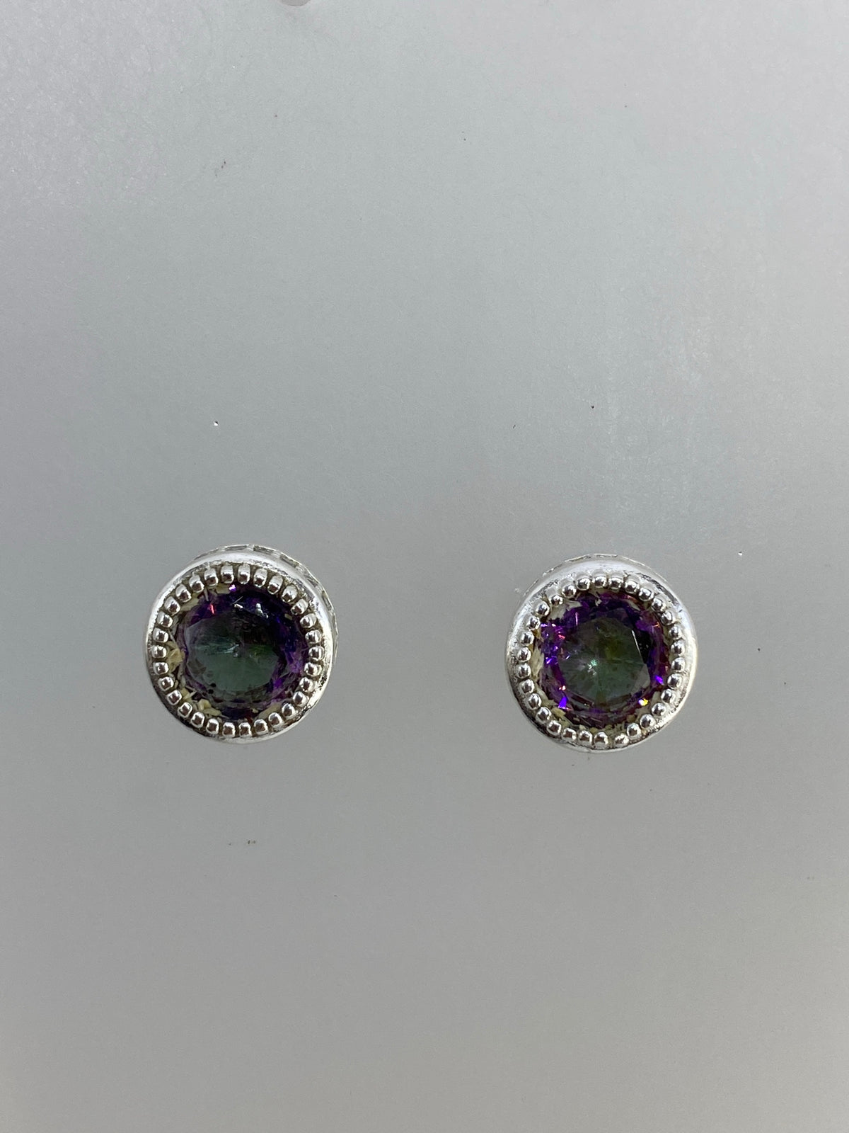 Detalle frontal de los aretes mostrando el engaste de circonia multicolor