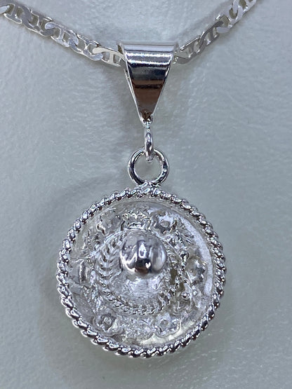 Dije de plata repujado de 3 cm con relieve volumétrico, visto de frente