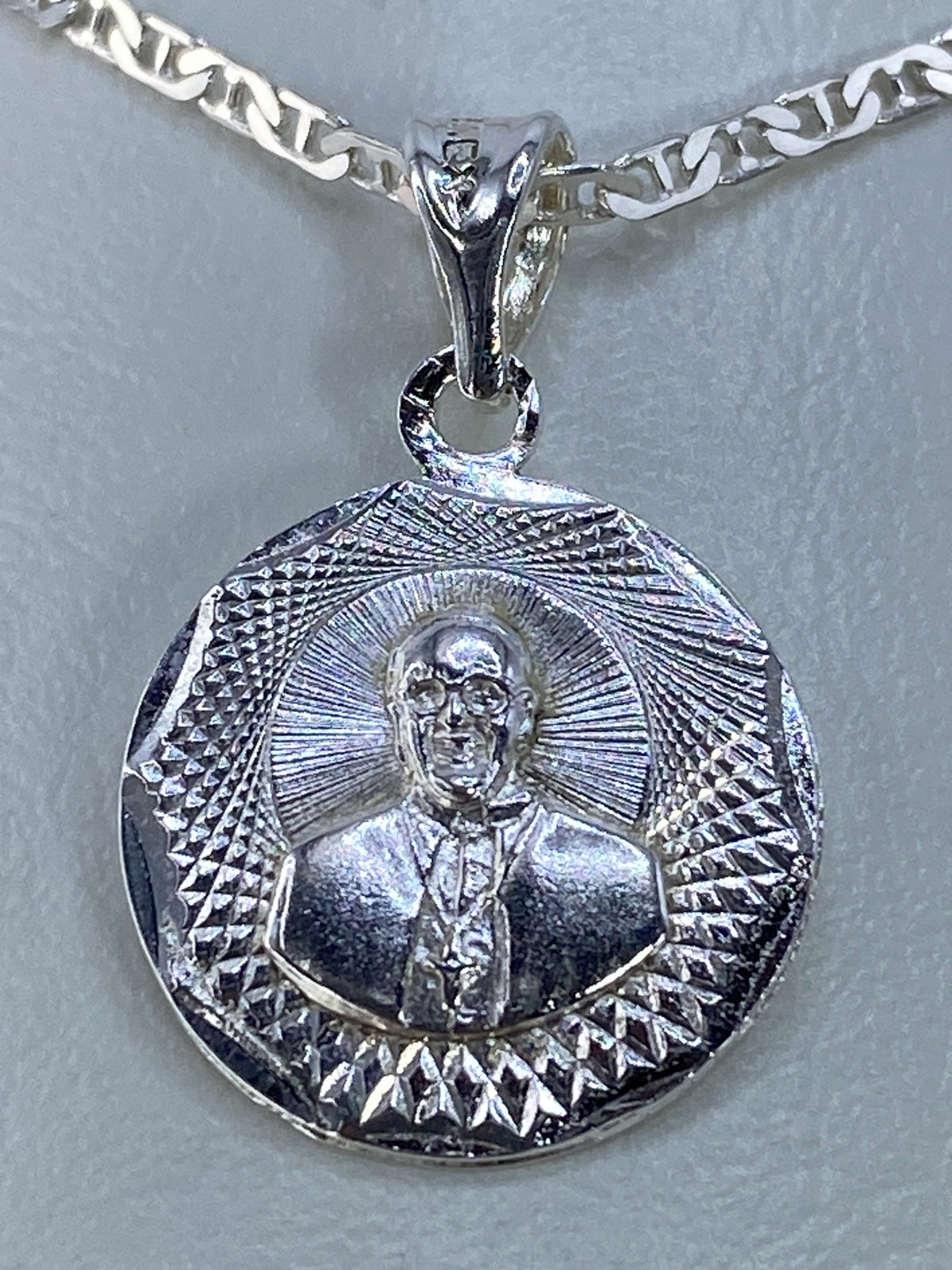 Dije espiritual de plata 925 visto de lado mostrando la profundidad del repujado