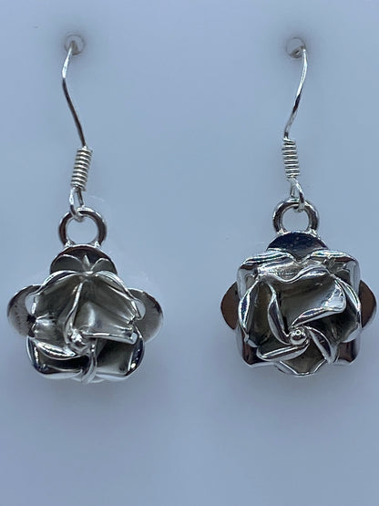 Par de aretes de plata 925 en forma de flor con repujado artesanal, colgando de ganchos de plata