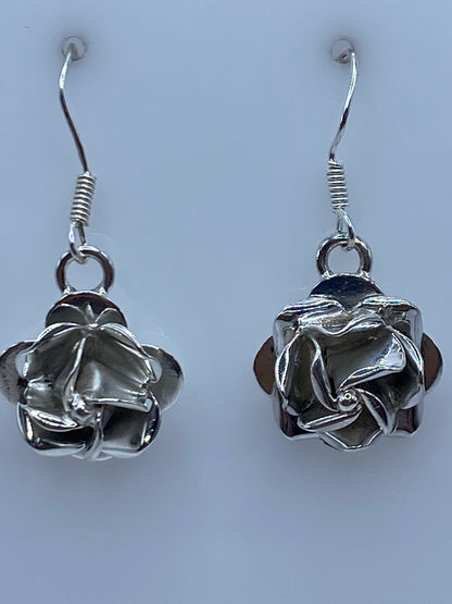 Aretes de plata sobre una regla de centímetros marcando el largo de 2.9 cm
