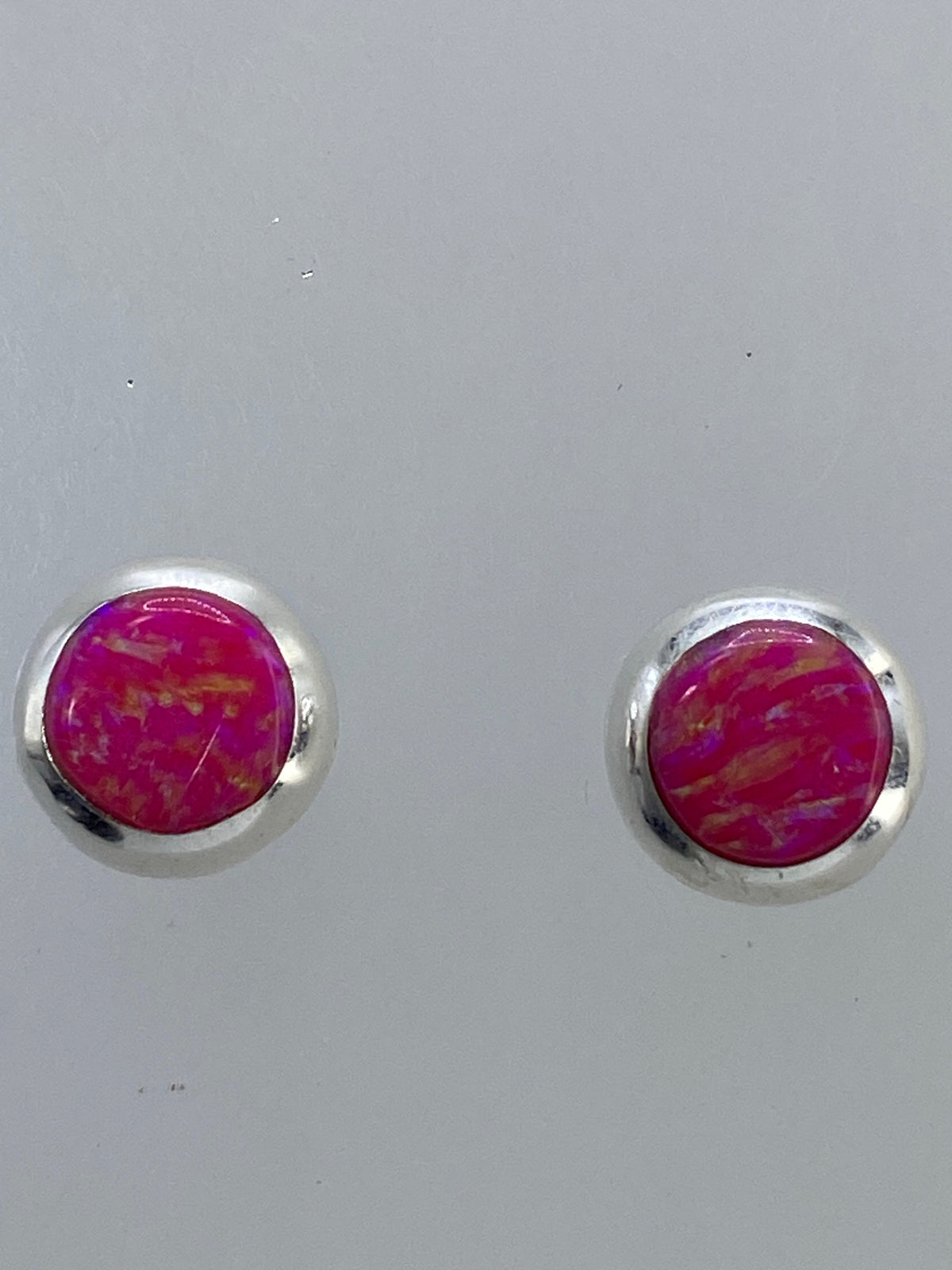 Aretes de ópalo de fuego sobre fondo blanco con cierre de presión visible