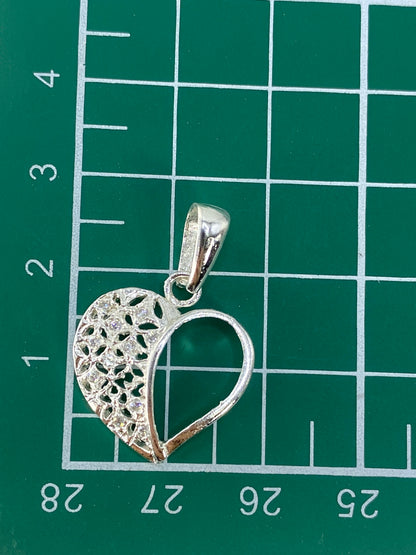 Corazón repujado de plata pura sobre fondo gris, mostrando el peso de 1.8 gramos