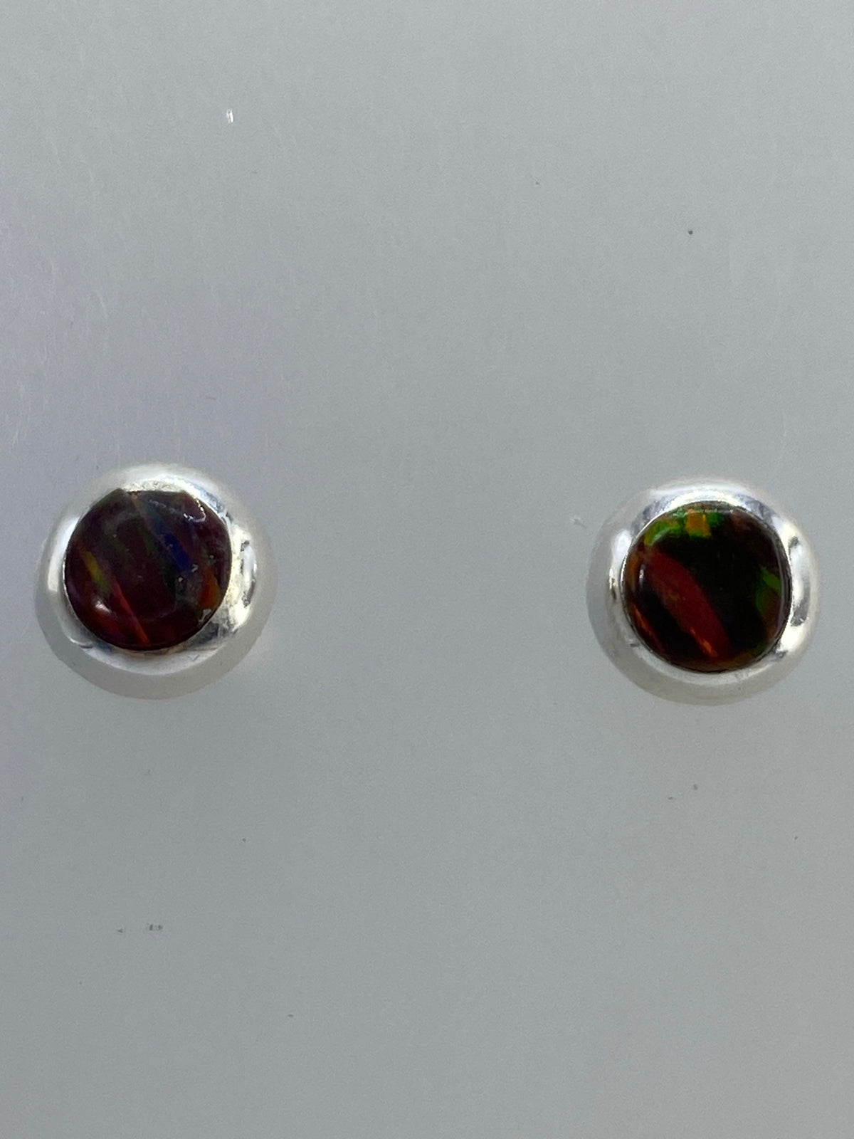 Aretes sobre medidor de escala mostrando tamaño compacto y peso de 0.85 g