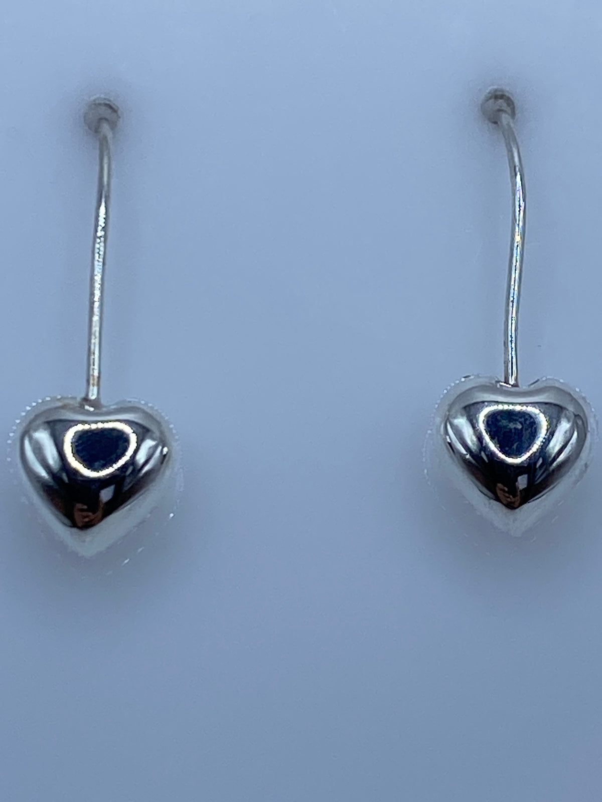 Aretes de plata sobre regla mostrando largo de 2.4 cm