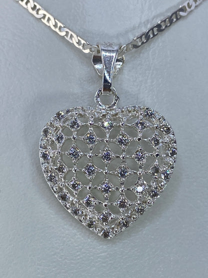 Dije corazón de plata 925 con micro-circonia brillante, colgando de una cadena plateada