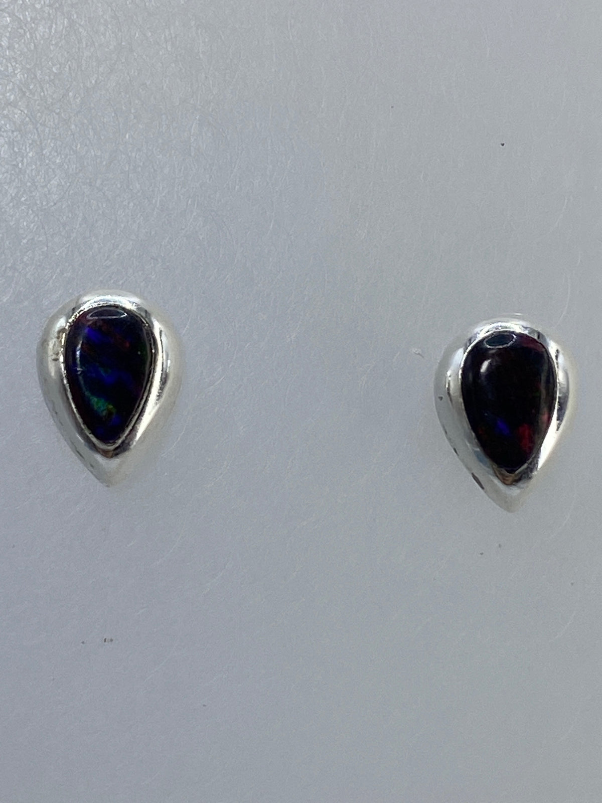 Par de aretes de plata con ópalo de fuego multicolor visto de frente