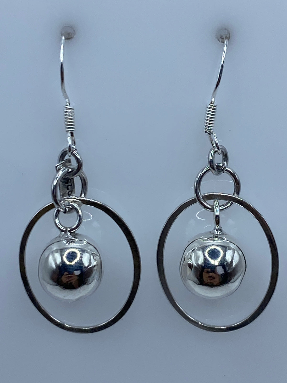 Aretes medidos en regla de centímetros, mostrando largo de 4.4 cm del par