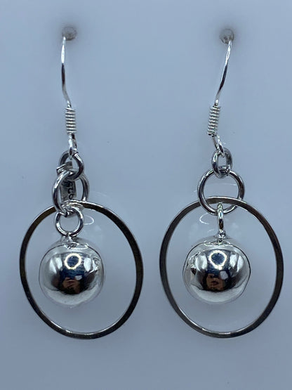 Aretes medidos en regla de centímetros, mostrando largo de 4.4 cm del par