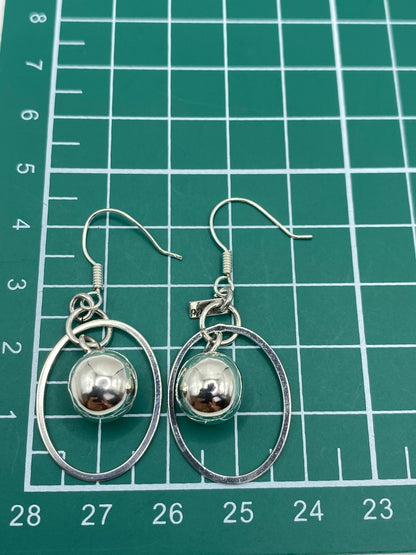 Aretes en escala de precisión mostrando peso de 4.95 gramos y marca 925
